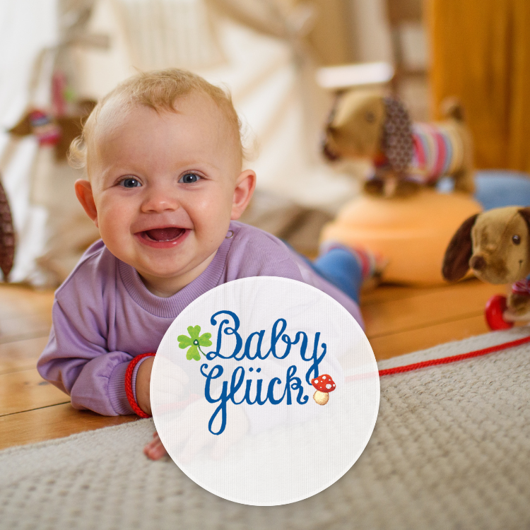 Ein Baby blickt lachend auf, im Hintergrund sind Dackel-Spielsachen zu sehen