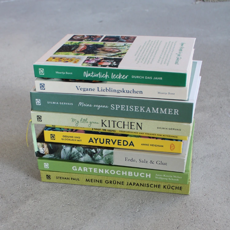 Bücherstapel mit verschiedenen Kochbücher, die alle vegetarische oder vegane Titel haben